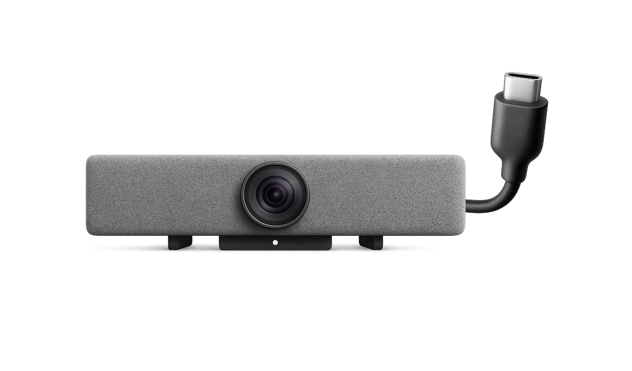 Front view of a rectangular gray webcam with a central camera lens and attached USB-C cable on a white background.
